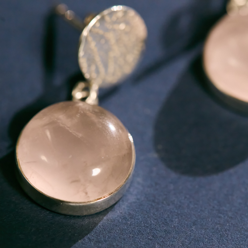 Detailed view of natural rose quartz bezel-set in high-quality 925 sterling silver. These artisanal drop earrings feature a unique hand-textured finish for a sophisticated look.
